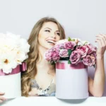Довольная девушка получает в подарок коробку с цветами от Romeo Flowers