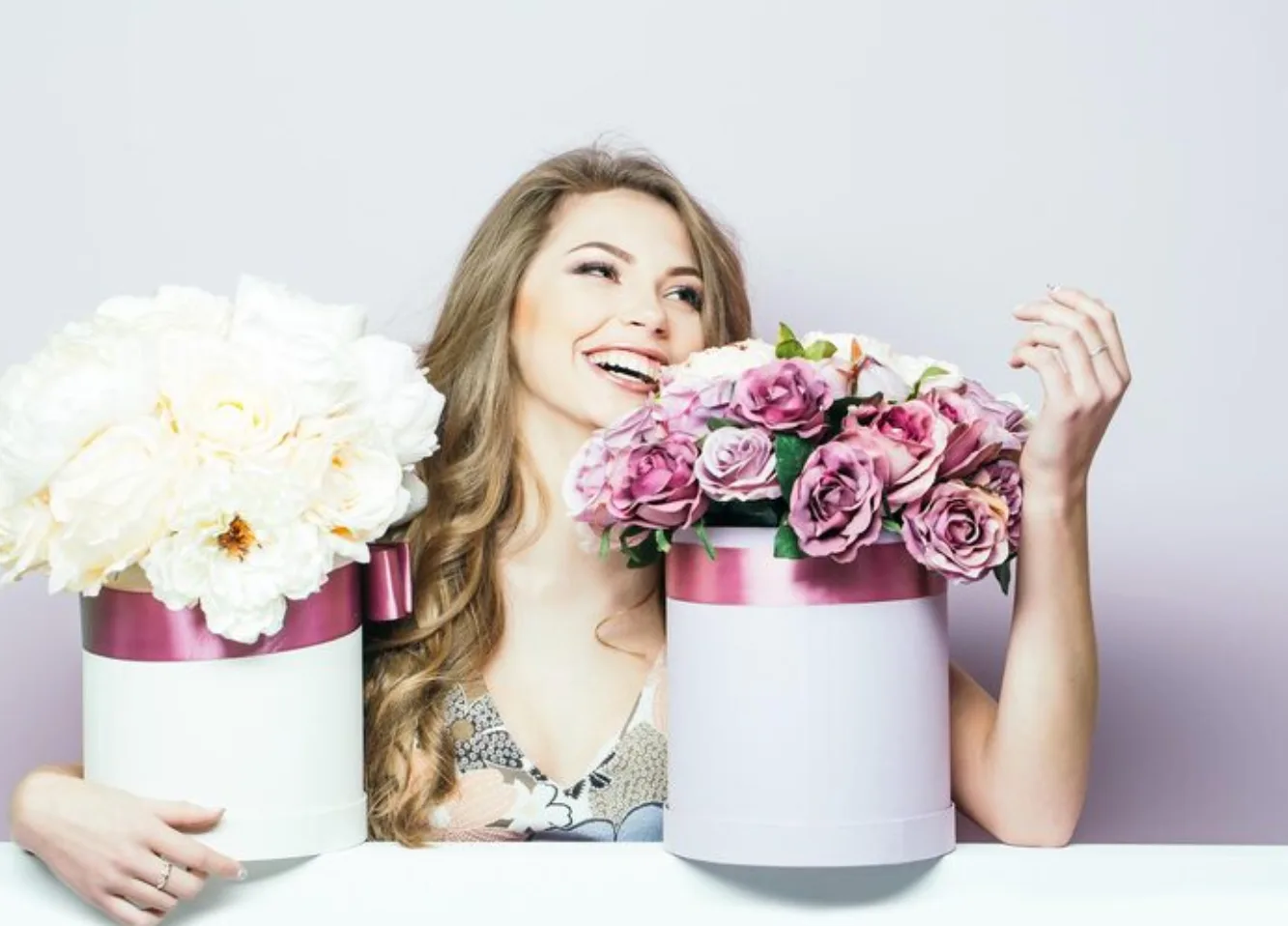 Довольная девушка получает в подарок коробку с цветами от Romeo Flowers